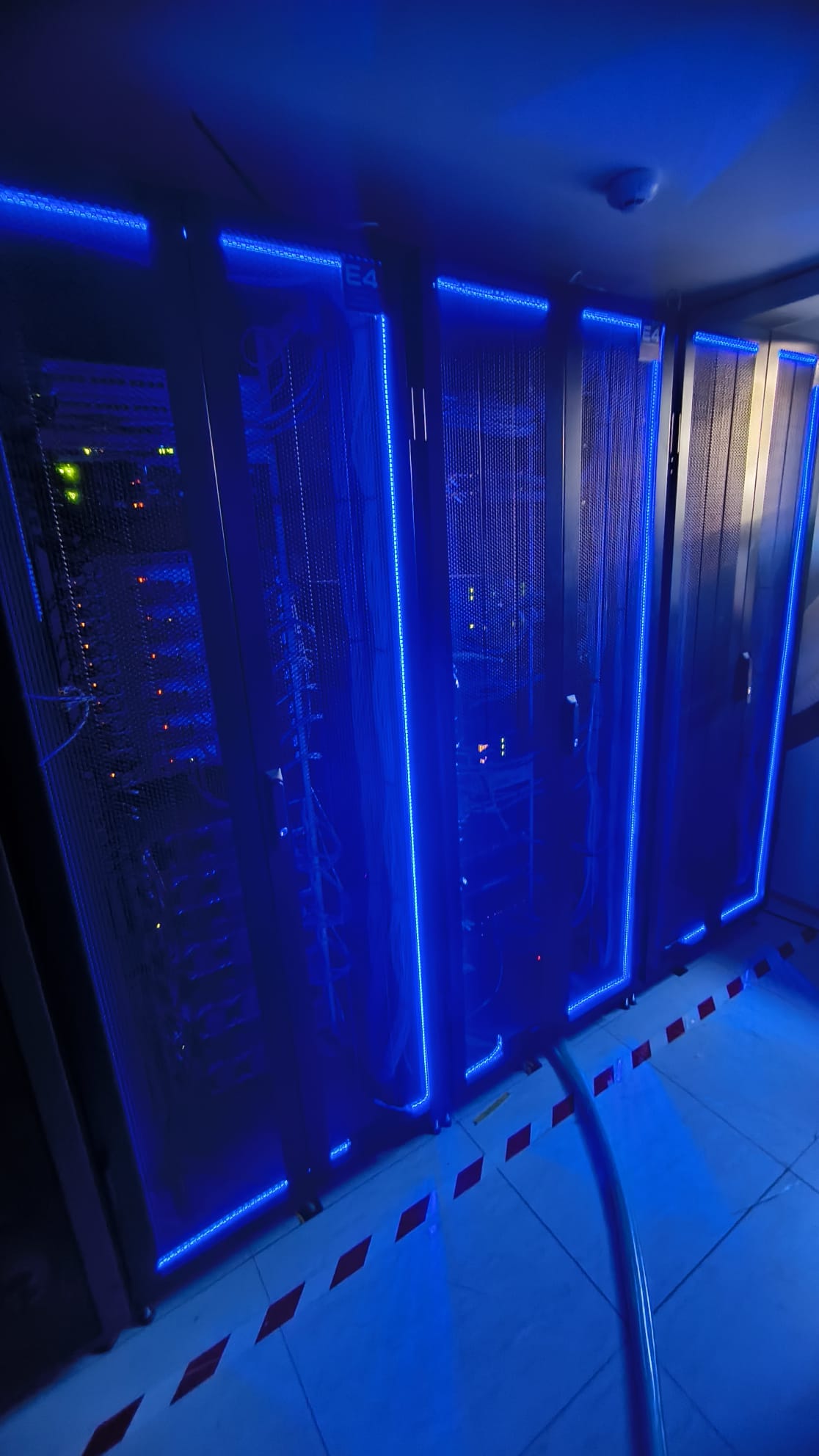 Il datacenter di ASTRI con server e apparecchiature illuminati da luci blu.
