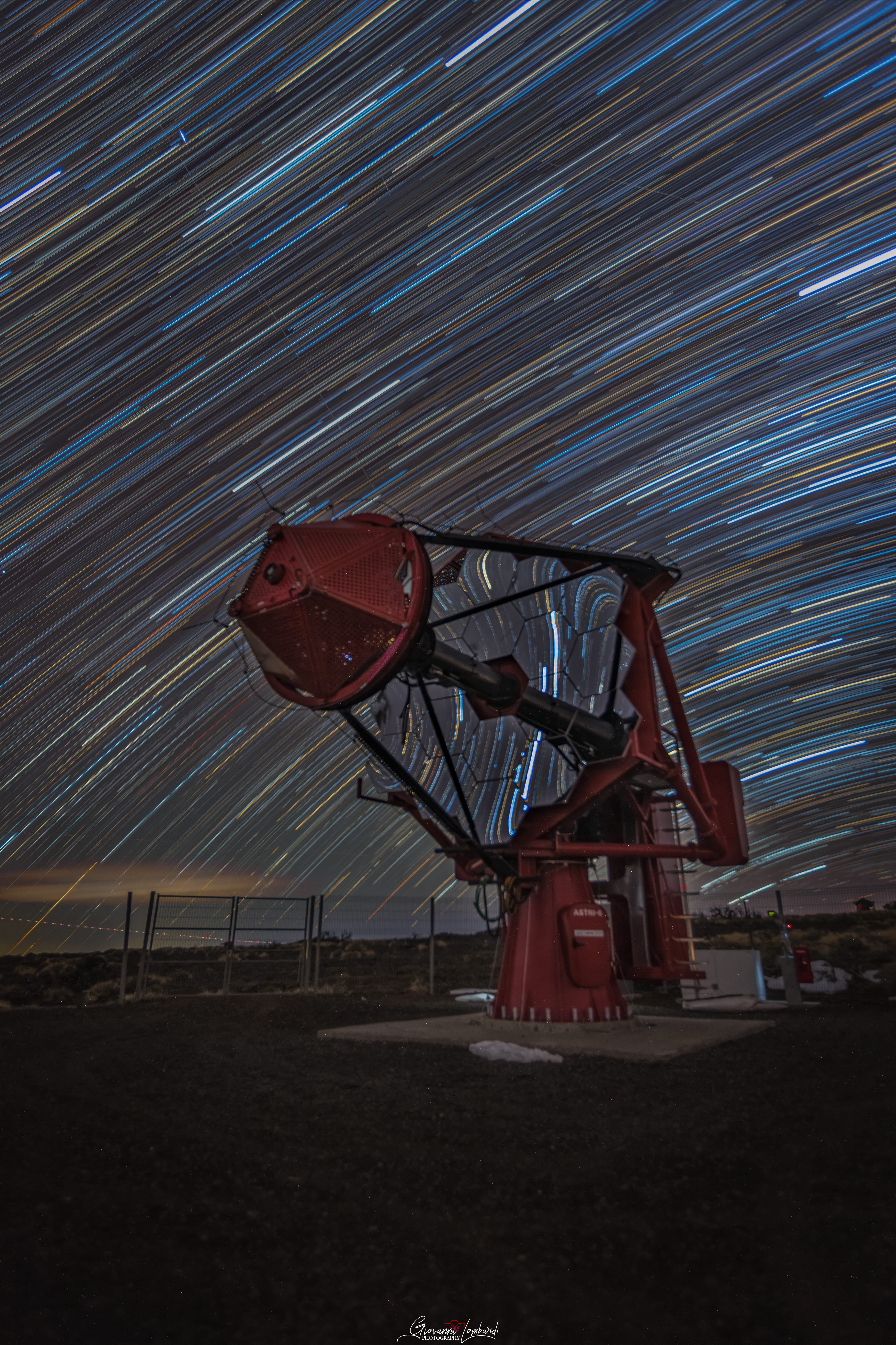 Scie stellari attraversano il cielo sopra il telescopio ASTRI-6 dell’ASTRI Mini-Array all’Observatorio del Teide (Tenerife). L’immagine, ottenuta con la tecnica dello star trail, mostra il moto apparente delle stelle dovuto alla rotazione della Terra.